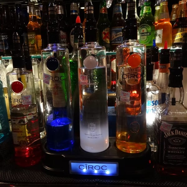 A bar display with various Cîroc vodka bottles, Jack Daniel's, and other liquor bottles.