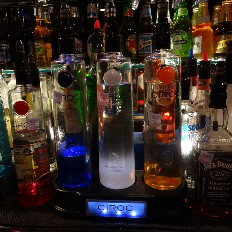 A bar display with various Cîroc vodka bottles, Jack Daniel's, and other liquor bottles.