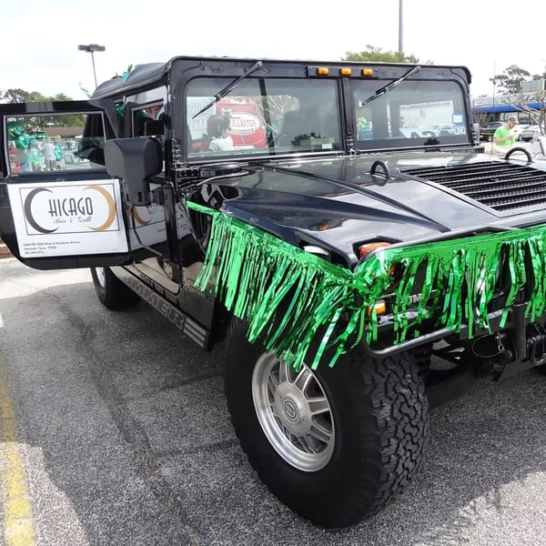Black Hummer with Chicago Bar & Grill logo on the door and green tinsel on the front.