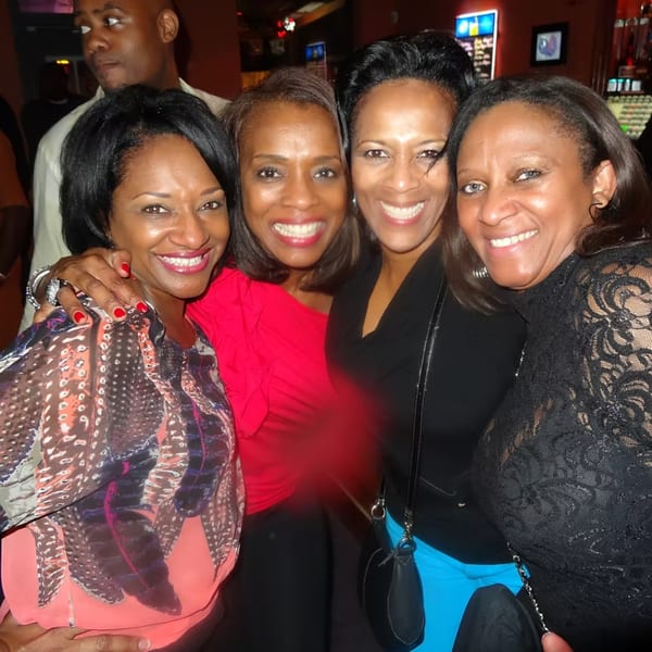Four smiling women posing for a photo at Chicago Bar & Grill, with a man in the background.