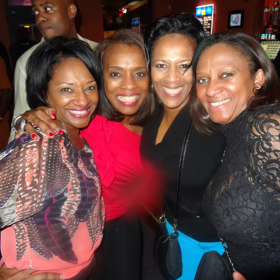 Four smiling women posing for a photo at Chicago Bar & Grill, with a man in the background.