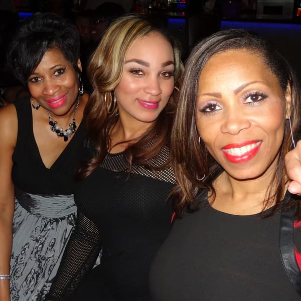 Three smiling women with bright red lipstick pose together at Chicago Bar & Grill.
