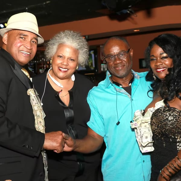 Four smiling people, two men and two women, posing together at Chicago Bar & Grill.