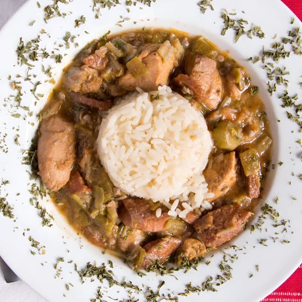 A white bowl of Chicago Bar & Grill's chicken and sausage gumbo with a scoop of white rice.